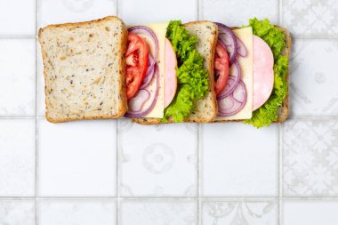 Jambonlu, peynirli, domatesli, soğanlı sandviç. Tam tahıllı bir sandviç için gerekli malzemeler. Üst görünüm