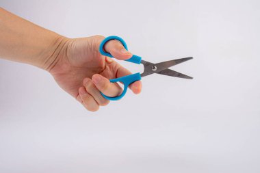 El ele tutuşan kırtasiye makası beyaz arkaplan izolasyonunu kesiyor