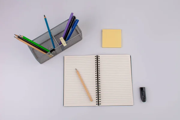 Stand stationery for pens in hand and notebook on a white background.