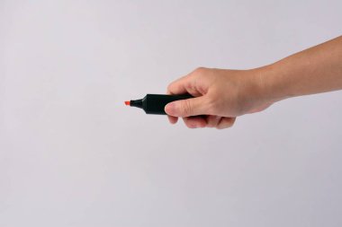 El, beyaz üzerine açık turuncu kalem tutuyor.