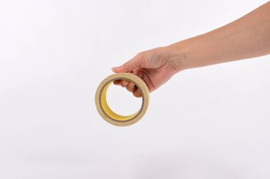 Holding ve beyaz bir arka plan üzerinde izole bir yalıtım bandı kullanan kadının elleri