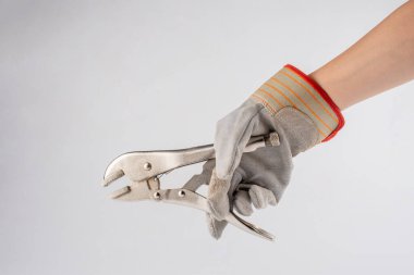 Beyaz arka planda el ele tutuşan pense ve mekanik eldivenler..