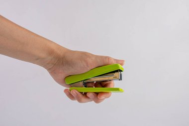 Hand and stapler, green stapler with hand pressed.