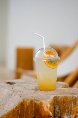 Iced lemonade soda with Yuzu orange on wood in cafe