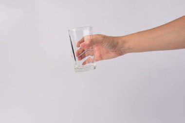 Hand and empty glass isolated on white background.