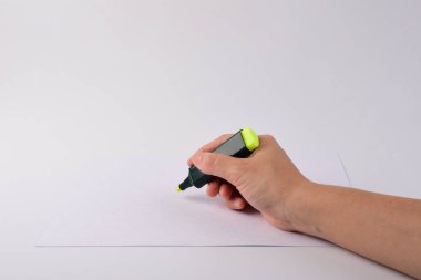 Hand holding open marker on white background.