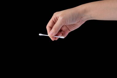 Hand picking cotton buds, black background