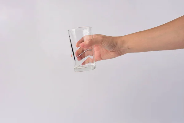 Hand and empty glass isolated on white background.