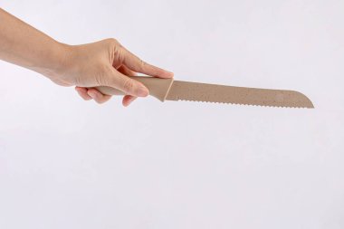 Hand and ceramic kitchen knife on a white background