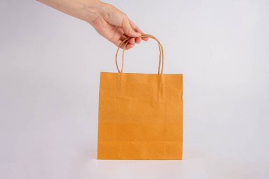 Beyaz arka plan üzerinde izole kese kağıdı tutan el.