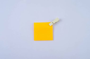 Beyaz üzerine izole edilmiş ahşap klipsli turuncu not 