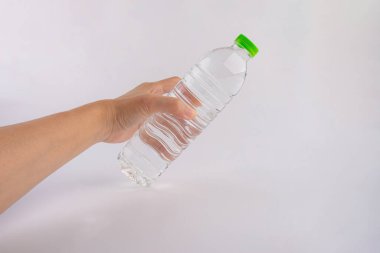 Beyaz arka planda izole edilmiş el ve plastik su şişesi.