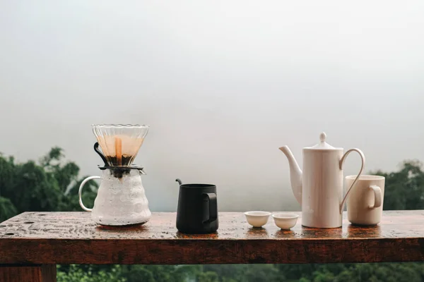 Drip coffee set on wooden table with mountain view in the background
