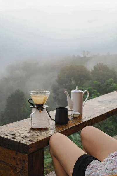 Drip coffee set on wooden table with mountain view in the background