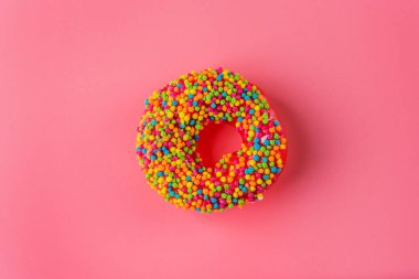 Çilekli jöleli çörek, ahududu, mandalina aromalı, pembe arka planda pasta serpiştirilmiş.