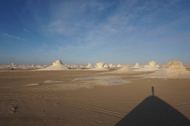 Mısır 'da, beyaz çöldeki bir tepede küçük bir insan gölgesi