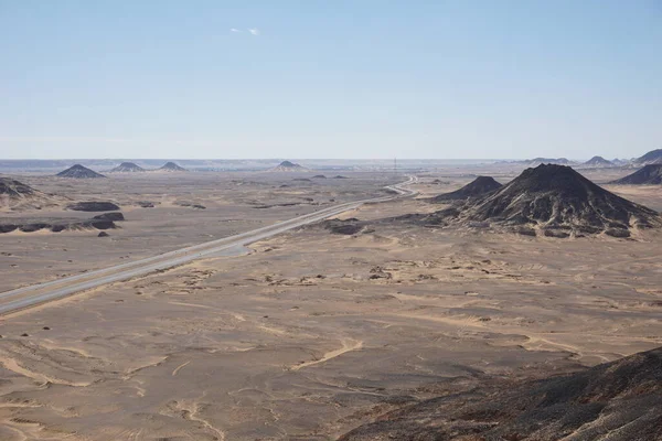 Black hills of the black desert along the road, Egypt