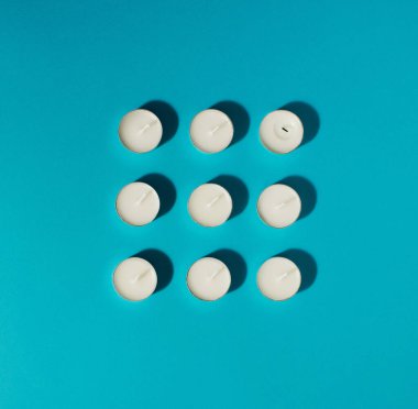 Parlak mavi arka planda beyaz mumlar. Asgari konsept.