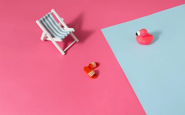 Summer scene with a pink flamingo, a deck chair and slippers. Minimal concept.