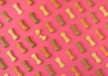 Pembe arka planda köpek bisküvilerinden yapılmış desen.