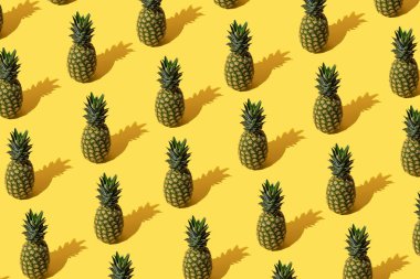 Sarı zemin üzerinde ananas olan yaz deseni.
