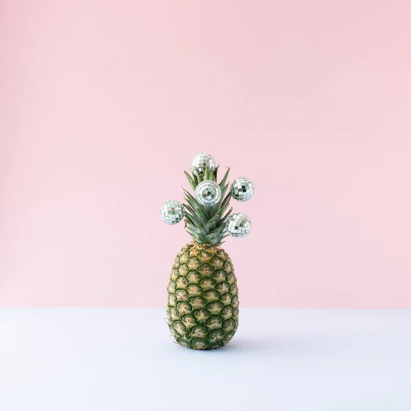 Yaz partisi geçmişi - Pastel arka planda disko topları olan taze ananas.