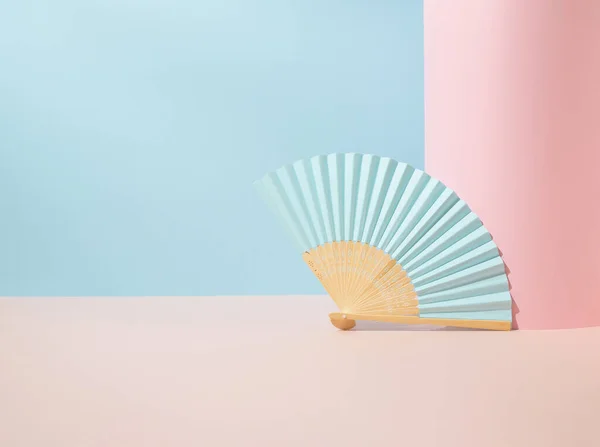 Geometrik mavi ve pembe arka planda mavi kağıt vantilatör. Asgari konsept.