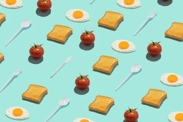 Kusursuz yaratıcı yemek kalıbı. Mavi arka planda tostlar, yumurtalar, domatesler ve plastik mutfak aletleri. Komik renkli kahvaltı konsepti.