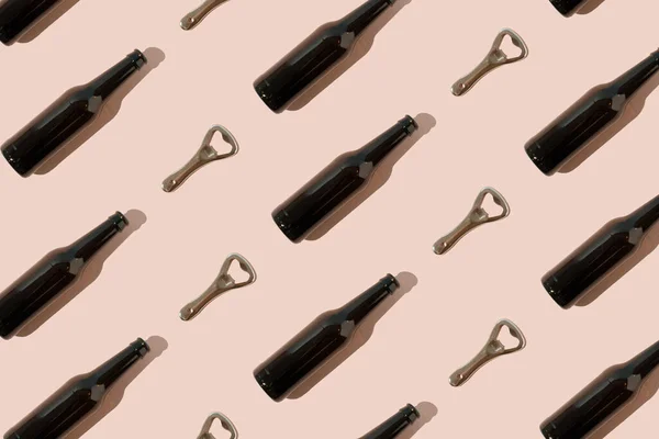 Pattern with brown beer bottles and metal bottle openers on pink background.