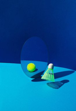 Badminton mekik horozu ya da kuş aynaya yansıyan mavi arka planda tenis topu gibi.
