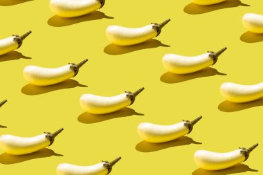 White aubergine eggplant pattern on yellow background. Minimal vegetable concept.