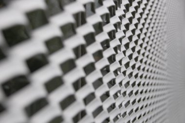 Yeşilimsi renklere, mimari dokuya sahip mikro delinmiş metal bir panele yakın çekim