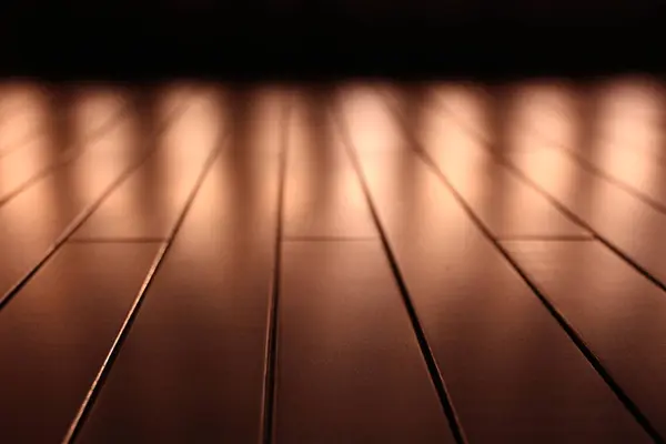 Theatrical spotlights turned on seen from the front on the reflective floor of the stage