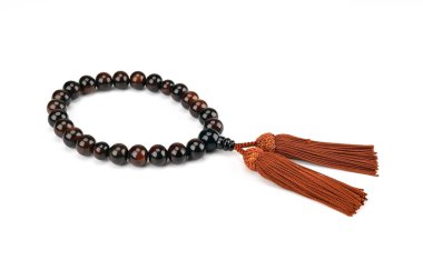 Küçük bir boncuk iplikle delinmiş ve iki tane püskül boncuğu var.