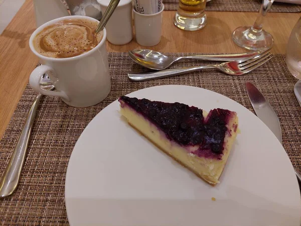 Cheesecake as dessert with afternoon coffee. Cheesecake is a dessert, probably from ancient Greece, which consists of two layers: a crust of crushed biscuits and a cheese layer.