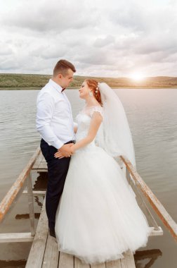 Genç bir düğün çifti rıhtımın yanında, yaz otlağında romantik anlar yaşıyor.. 