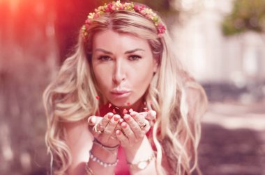 Genç bir kadın havaya kalp şeklinde renkli konfeti üflüyor. Etrafı konfetilerle çevrili mutlu bir kadın.. 