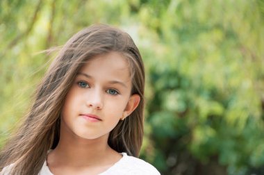 Parktaki güzel küçük kız, uzun saçlı ve tatlı, nazik bakışlı. Mutlu çocukluk kavramı. 