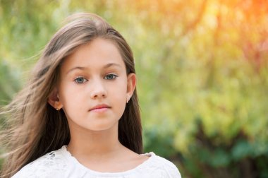 Parktaki güzel küçük kız, uzun saçlı ve tatlı, nazik bakışlı. Mutlu çocukluk kavramı. 