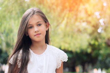 Parktaki güzel küçük kız, uzun saçlı ve tatlı, nazik bakışlı. Mutlu çocukluk kavramı. 