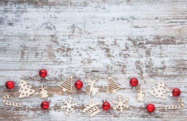 Noel deseni. Ahşap Noel oyuncakları ve kırmızı Noel topları olan bir arka plan. Yeni yıl sembolleri. Düz yatış, üst görünüm. 