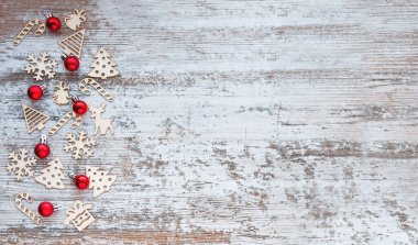 Noel deseni. Ahşap Noel oyuncakları ve kırmızı Noel topları olan bir arka plan. Yeni yıl sembolleri. Düz yatış, üst görünüm. 