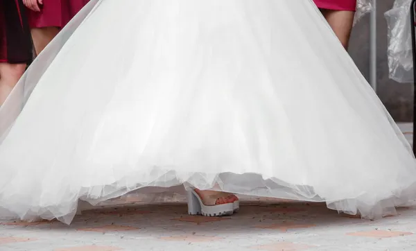 新娘穿鞋子 穿着白色婚纱长腿的新娘的鞋子 — 图库照片