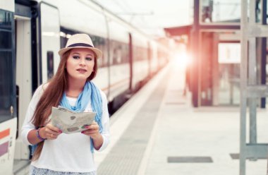 Gezgin kız tren peronunda bekliyor ve trene biniyor. Seyahat kavramı.