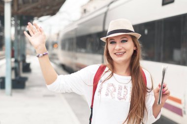 Tren istasyonunda elini sallayan güzel bir kız. Buluşmayı beklemek, seyahat etmek, sevgililerle tanışmak. Yeni bir ülkeye seyahat. Taşınıyor. 
