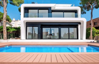 Alacakaranlıkta yüzme havuzlu lüks bir villa. Çağdaş bir evin dış görünüşü. İnşaatta yeni teknolojiler.  