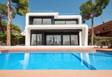 Alacakaranlıkta yüzme havuzlu lüks bir villa. Çağdaş bir evin dış görünüşü. İnşaatta yeni teknolojiler.  