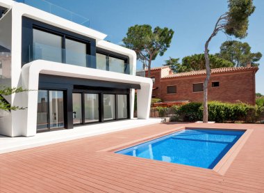 Alacakaranlıkta yüzme havuzlu lüks bir villa. Çağdaş bir evin dış görünüşü. İnşaatta yeni teknolojiler.  