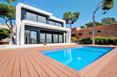 Alacakaranlıkta yüzme havuzlu lüks bir villa. Çağdaş bir evin dış görünüşü. İnşaatta yeni teknolojiler.  