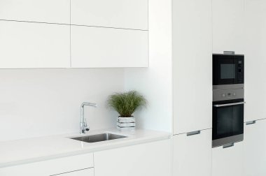 Beyaz mutfak iç kısmı. Minimalist iç tasarım. Modern mobilyalar ve dahili aletler.